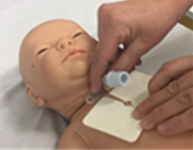 Person sliding the new tracheostomy dressing behind the neckplate - please see instructions below