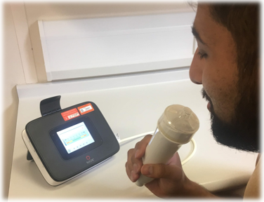 An exhaled nitric oxide meter and breathing handle being used by a person for performing an exhaled nitric oxide measurement.