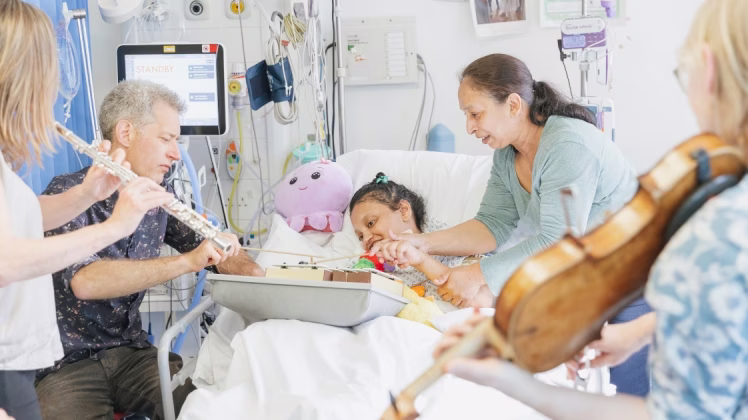 A patient plays an instrument on an ICU Ward.