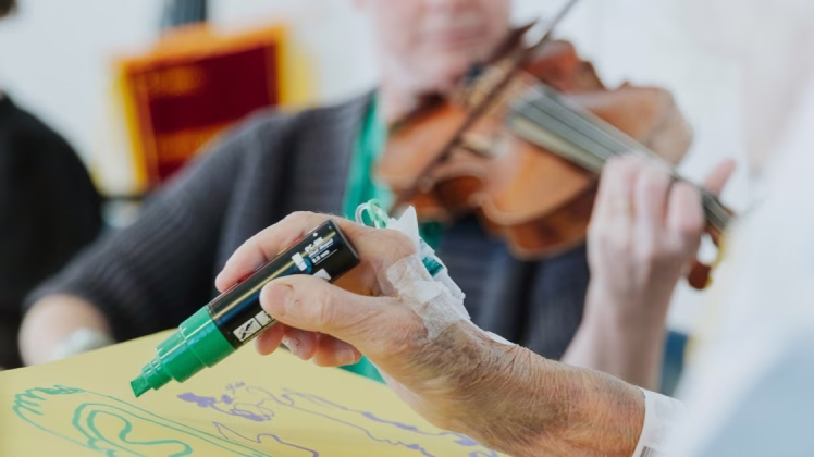a musician plays for a patient who draws