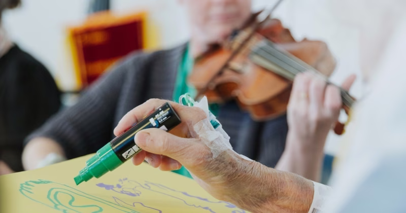 a musician plays for a patient who draws