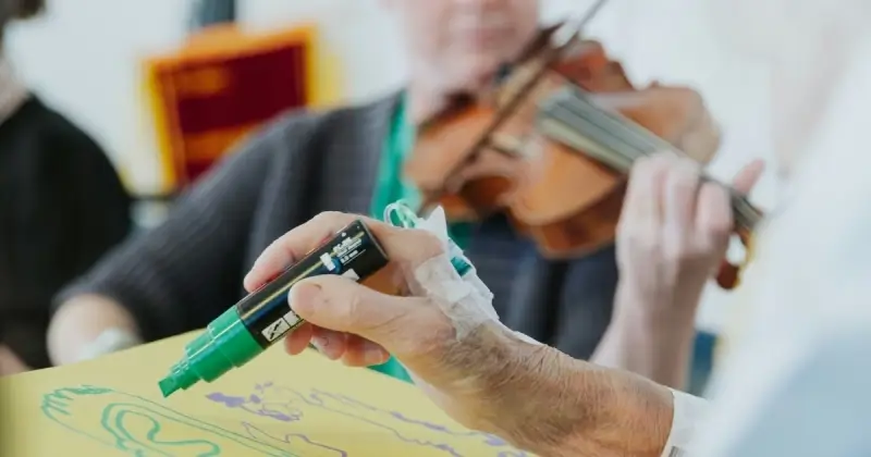a musician plays for a patient who draws