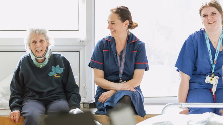 Two staff members listen to music with a patient on an ICU ward.
