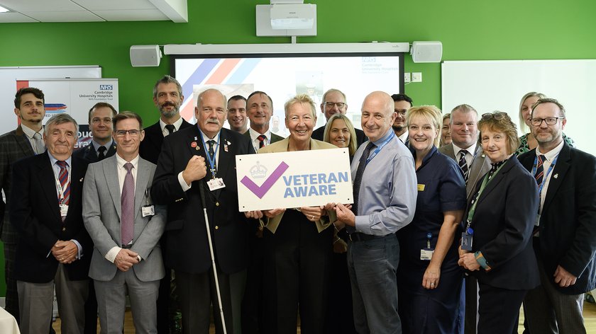 Line up of all attendees at Veteran Aware event with Julie Spence and Mike More holding a up an image of the Veteran Aware accreditation logo