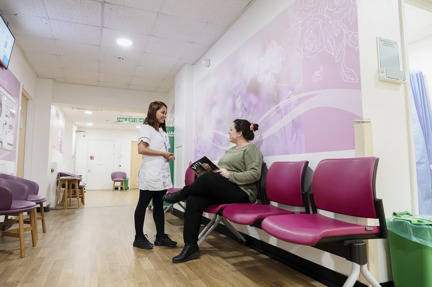 A patient talking to a nurse in the Breast Unit waiting room