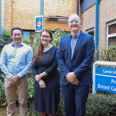 Three researchers standing outside the Breast Unit
