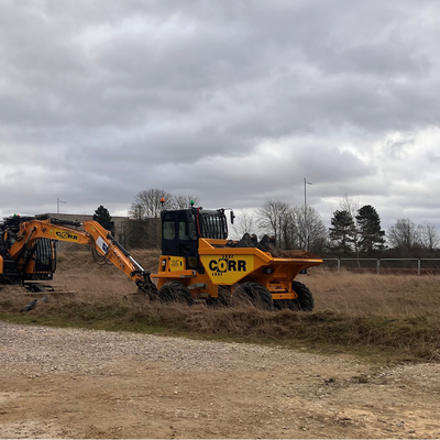 A yellow digger on a muddy site