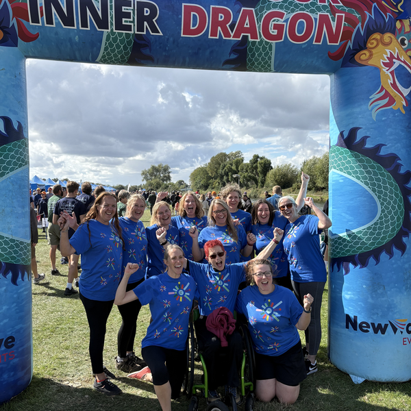 A photo of a group of people in front on a inflatable banner reading 'unleash your inner dragon'