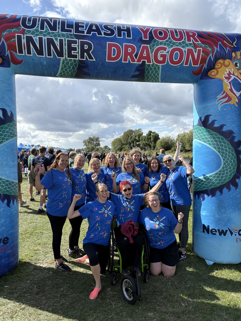 A photo of a group of people in front on a inflatable banner reading 'unleash your inner dragon'