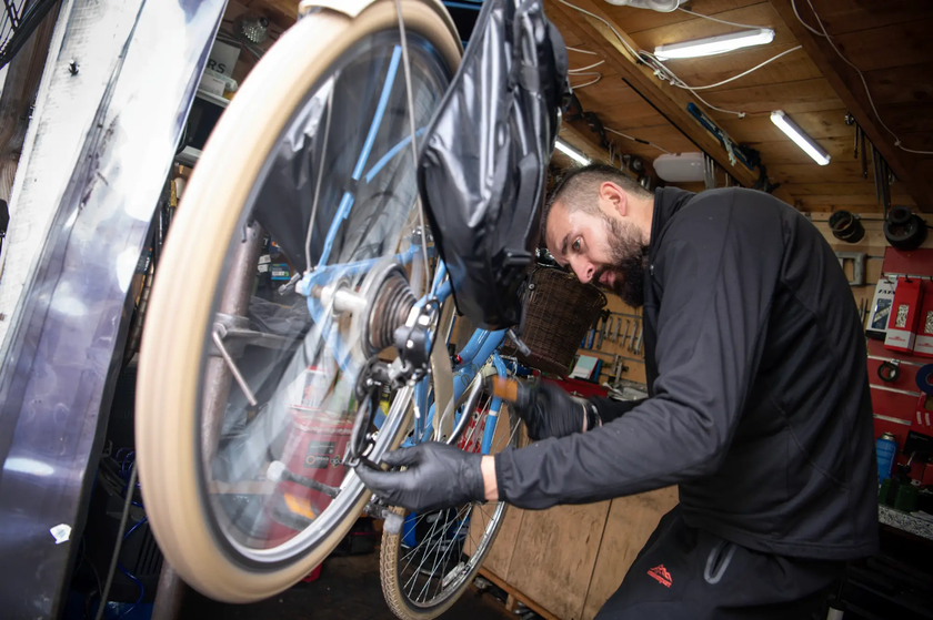 campus cycle colleague works on a repair to a bicycle