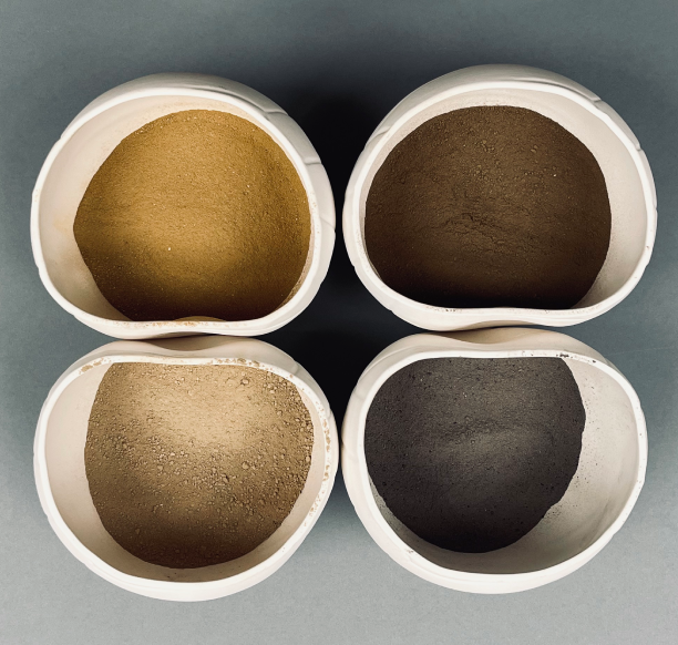 Four vessels containing organic powdered glazes of different colours.