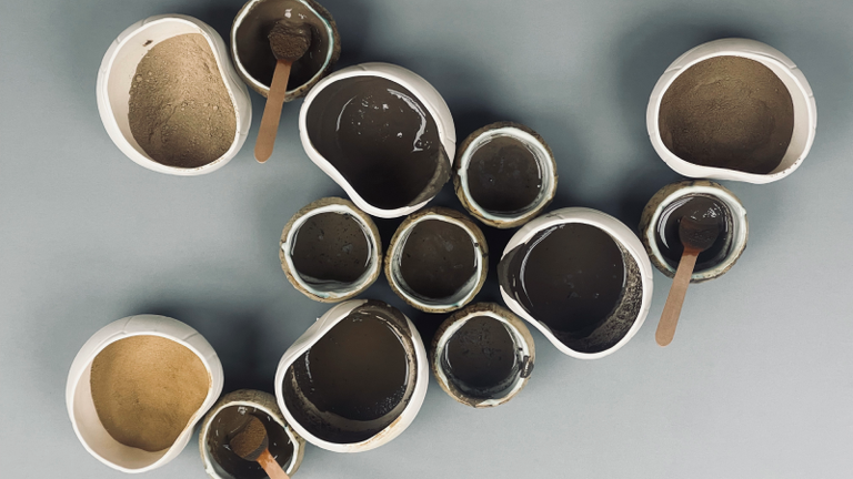 Mixing ceramic glazes from natural materials in white vessels.