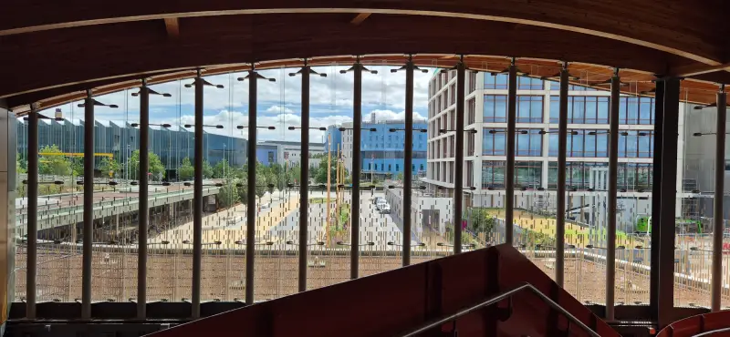A view from inside the station across the campus showing the drop-off bay in the foreground with Addenbrooke's, Papworth and AstraZeneca behind.