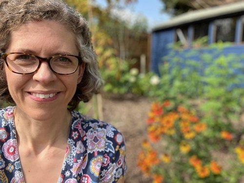 A lady in the garden wearing a paisley dress