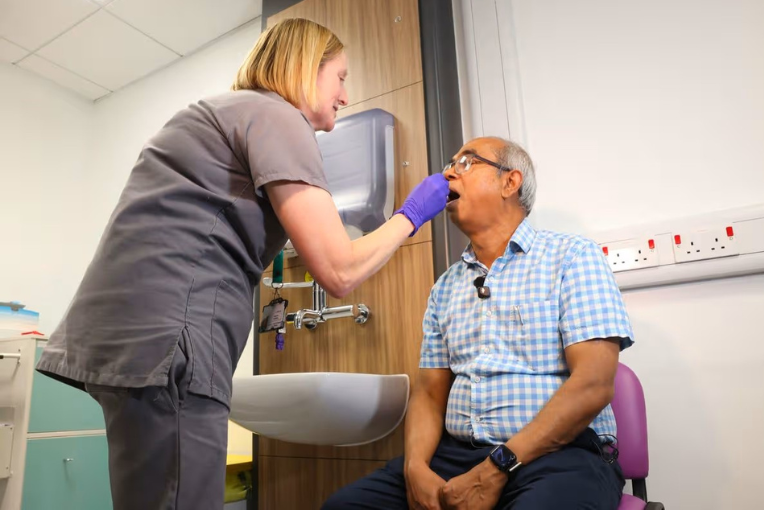 Advanced care practitioner Suzanne Hawkins swabs the mouth of patient Ashraf Ali at the new minor stroke clinic at the Queen’s Medical Centre in Nottingham.
