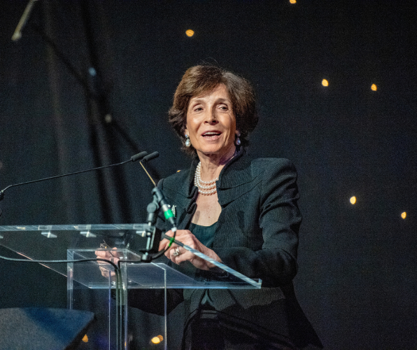Dame Mary Archer standing at a podium