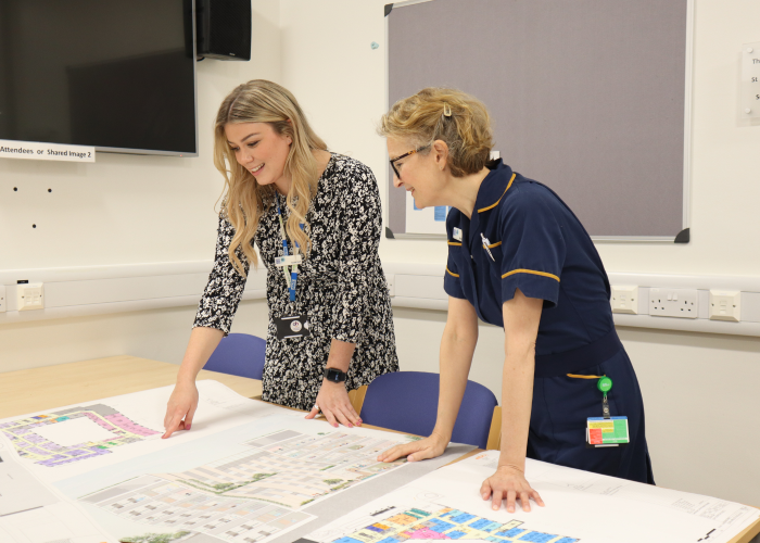 A woman and nurse looking over floor plans of the new Cancer Hospital