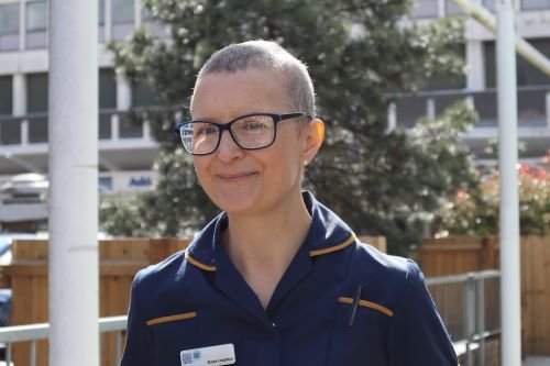 A nurse wearing glasses smiling
