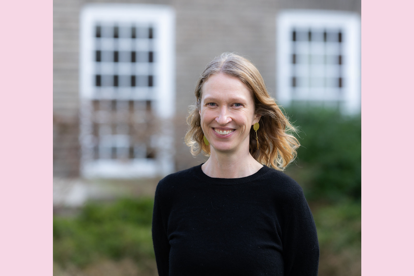A smiling woman with long light blondish brown hair and black jumper