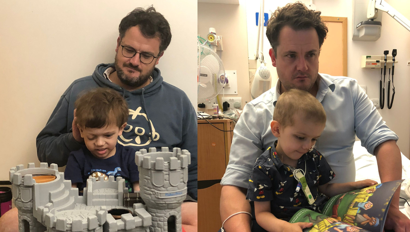 A man with brown hair and glasses, who looks very sad, sitting with his young son who has cancer. His son is playing