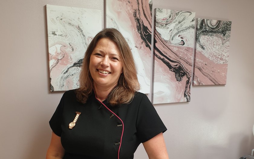 Helen Lee standing in front of pink and black artwork