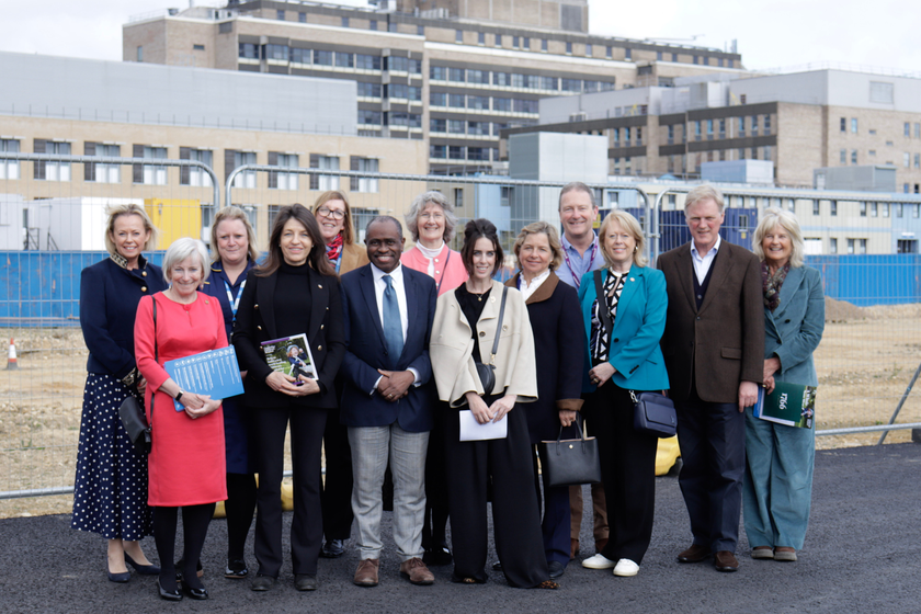 A group of people standing outside the Cambridge Children's Hospital site on a sunny day.