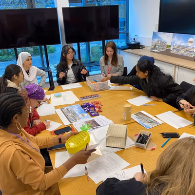 A group of teenagers sitting around a table doing a workshop