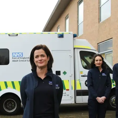 Adult critical care ambulance and crew members standing in front of it