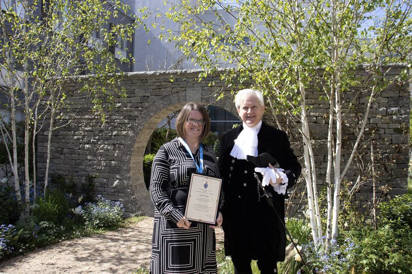 The High Sheriff of Cambridgeshire with Callie Ansell in the garden holding a certificate