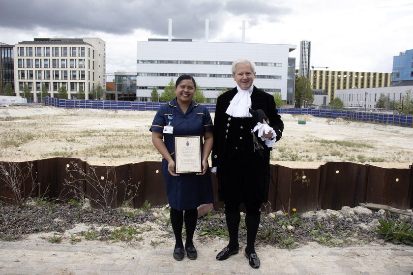 The High Sheriff of Cambridgeshire presenting an award to a nurse overlooking a building site.