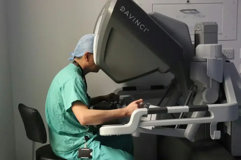 Man sat at desk using 'da Vinci' surgical robot terminal