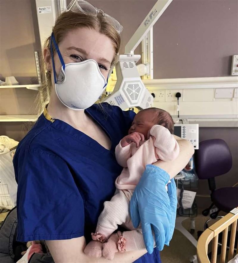 Midwife Rosie Riches holding baby. Picture by Annalisa Ross.