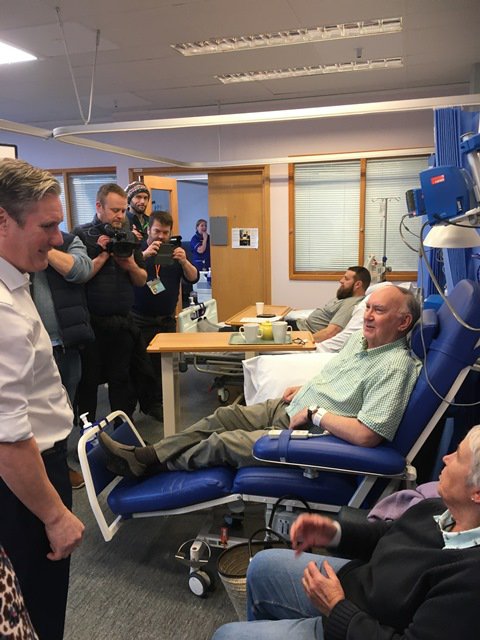 Keir Starmer is talking to patients at Addenbrooke's and is surrounded by photographers and interviewers.