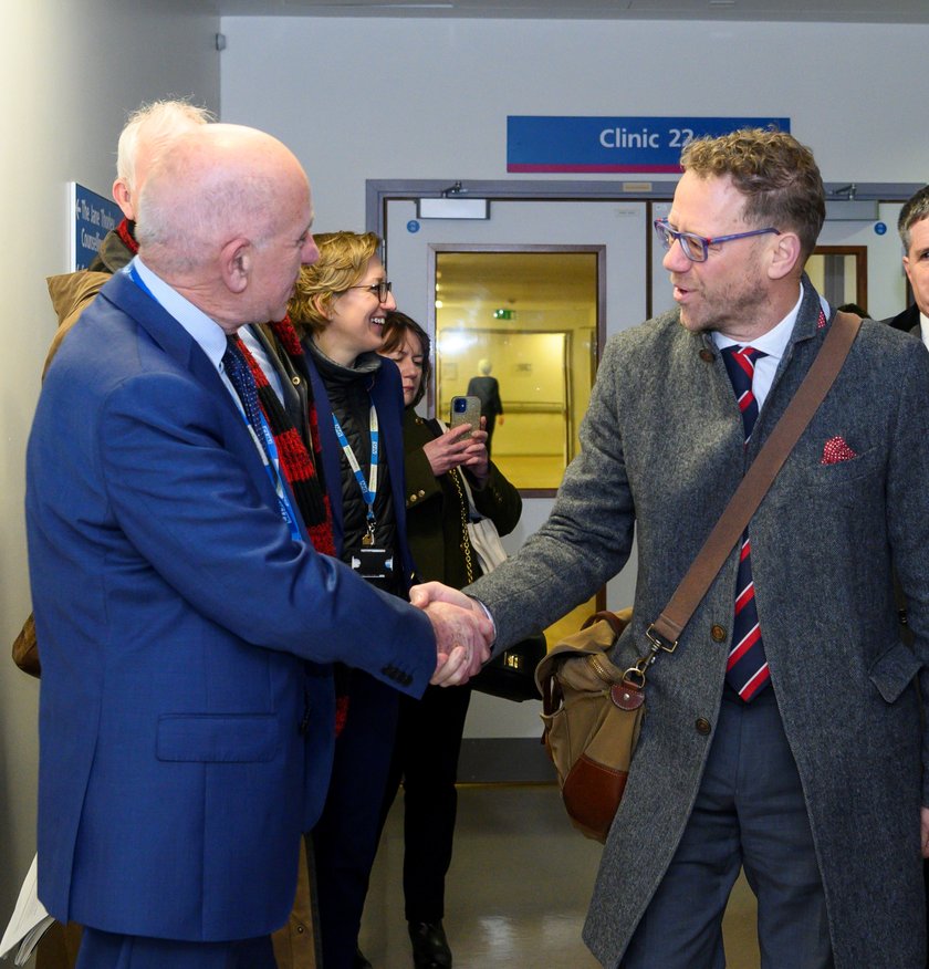 Two men smiling and shaking hands