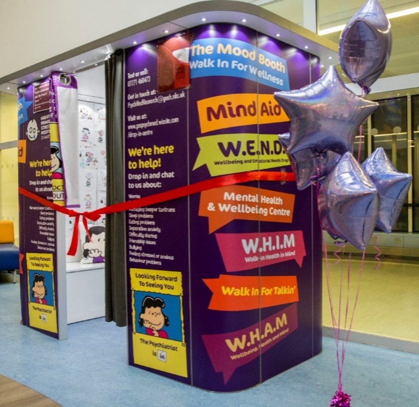 A colourful booth with images of Lucy from the Peanuts cartoon and a big red ribbon around it