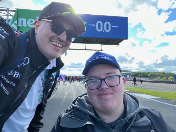 A father and son wearing caps at silverstone car racing