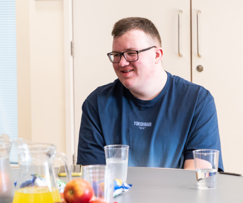 A teenage boy wearing glasses smiling