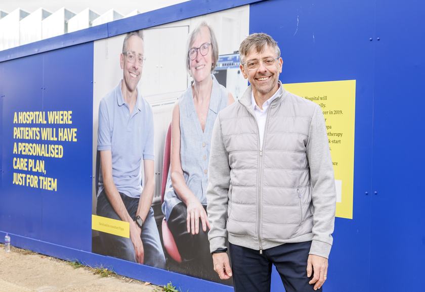 David Bateson, Members of the Cambridge Cancer Research Hospital Patient Advisory Group stands in front of his image on the new CCRH site hoardings