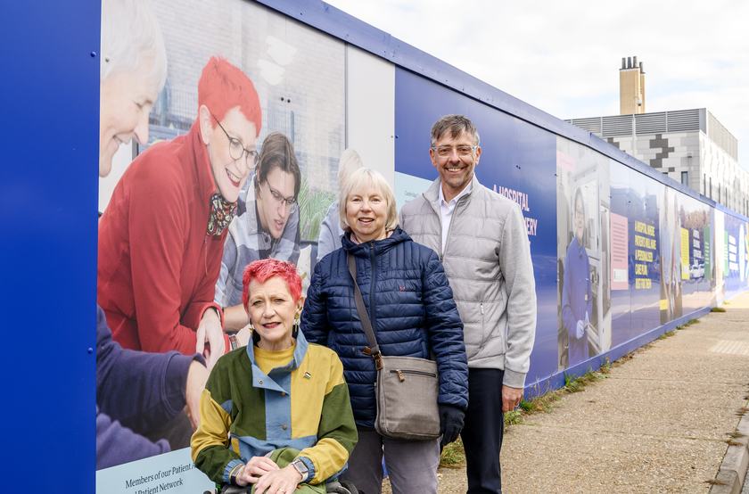Members of the CCRH Patient Advisory Group Fiona Carey and David Bateson, and Doreen Silman, partner to the late Patient Advisory Group member Paul Middleton, pictured in front of the Cambridge Cancer Research Hospital hoardings.