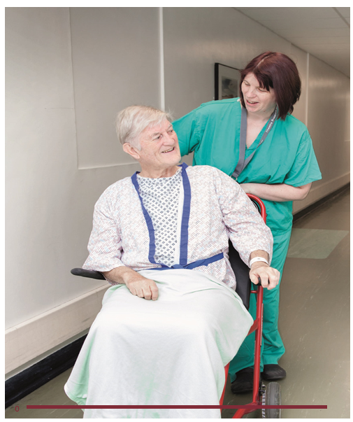 Man sitting in a wheelchair being pushed by a member of the Uppper GI Surgery team