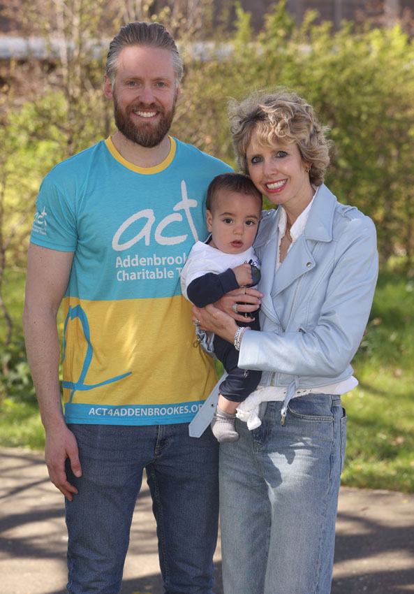 A man and a women holding a child outside