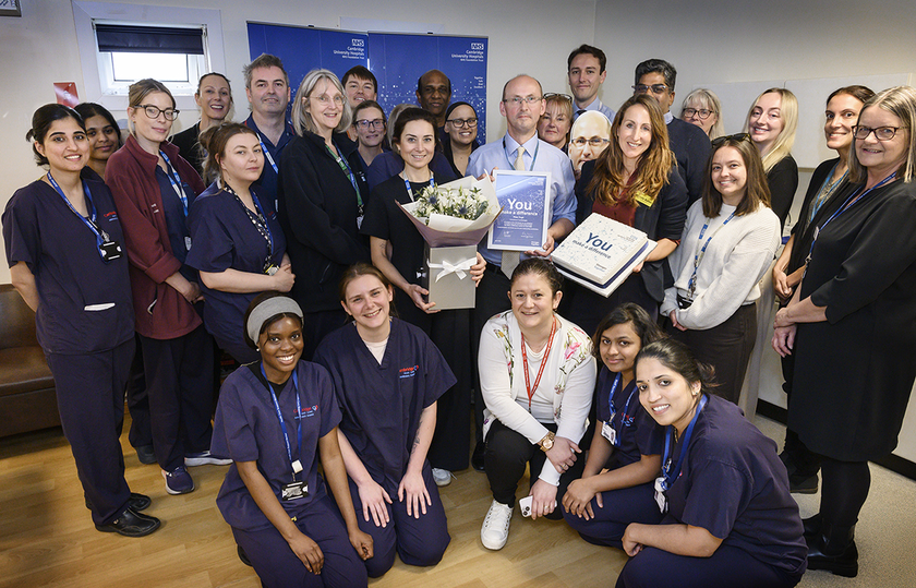 Peter Pugh surrounded by his team, friends and colleagues, smiling and looking happy