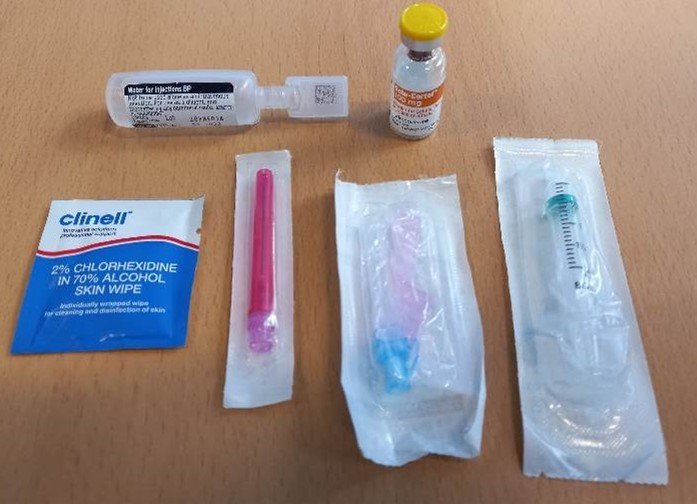 Equipment laid out: Clinell wipe, 2ml syringe, Blue needle, Red filter needle, Hydrocortisone vial, Water for Injection ampule