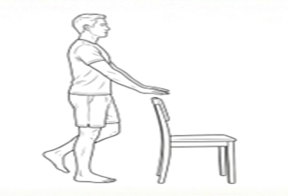 Standing knee bend exercise using a chair for support, lifting one foot behind the body.