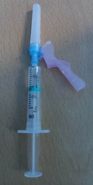 Loaded syringe with blue 'giving' needle attached