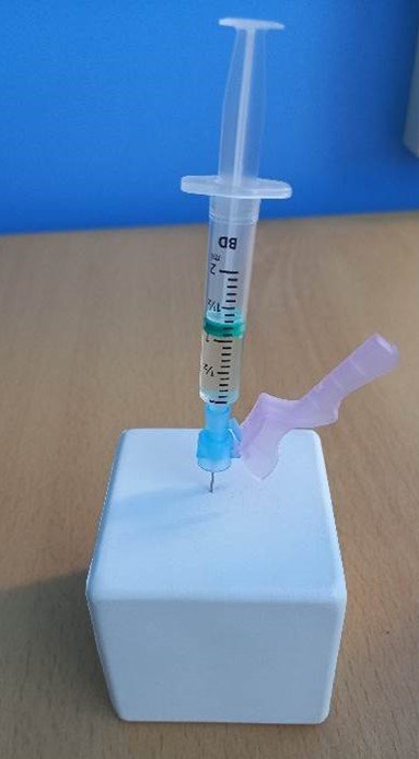 Needle being inserted into a white block as demonstration