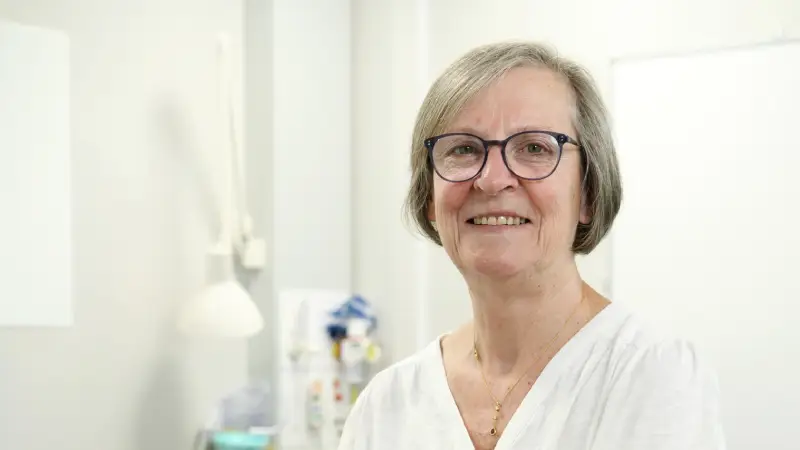 Pippa Corrie facing the camera in a clinical room