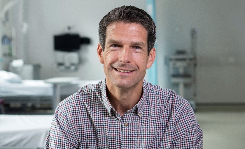 A photo of a man wearing a stripey shirt with short brown hair