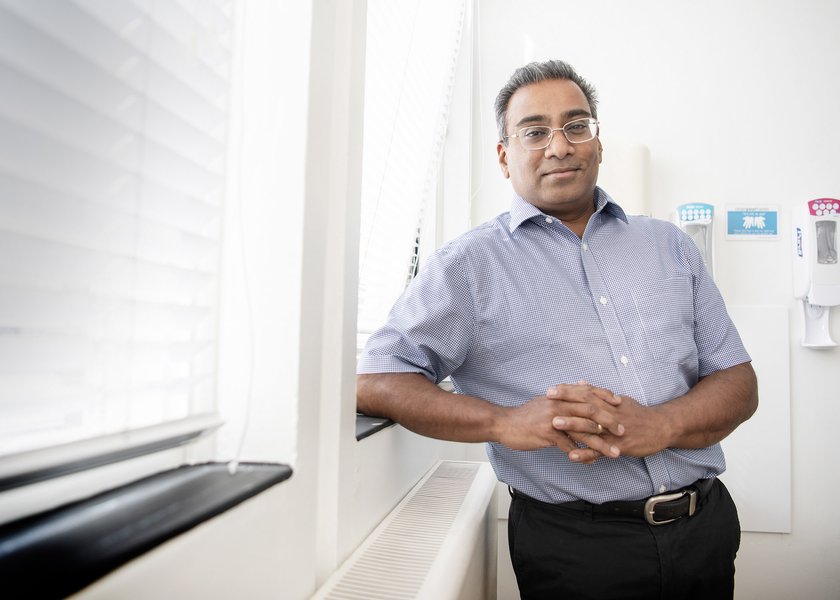 Professor Vincent Gnanapragasam leaning against a window in a hospital