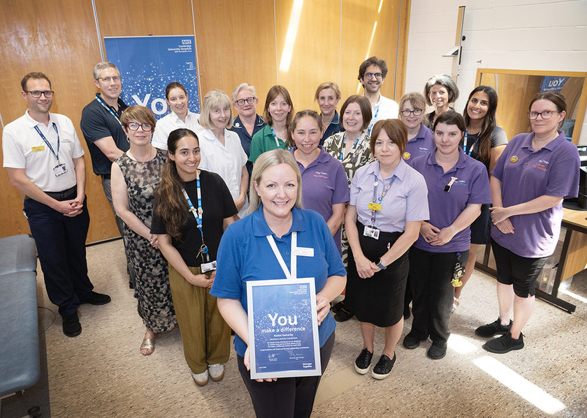 Rachel with her team and colleagues, shes is holding her certificate and smiling at the camera